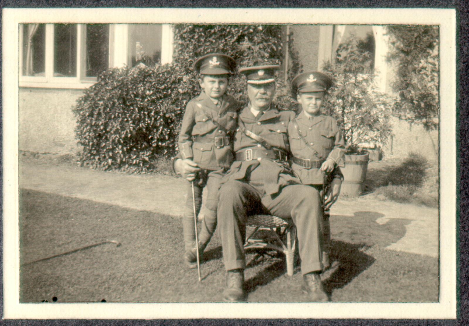 A black and white photograph of Conan Doyle with his sons on his knees